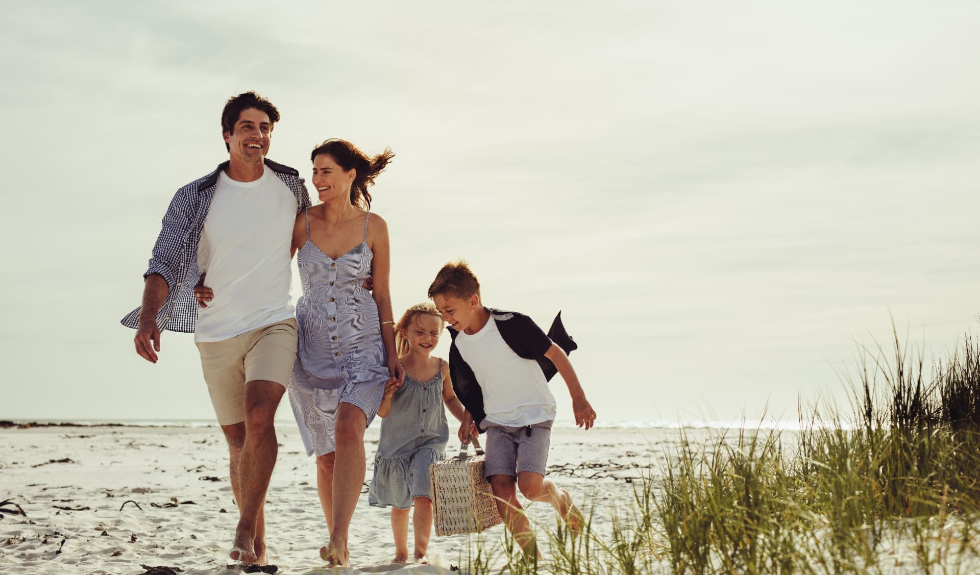 Family walking together on the beach at golden hour